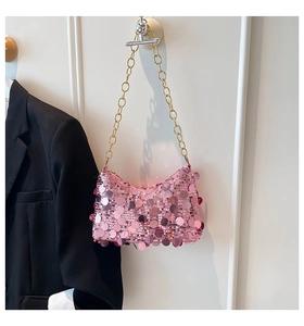 Gros plan d'un sac croissant à paillettes roses avec chaîne dorée sur fond blanc