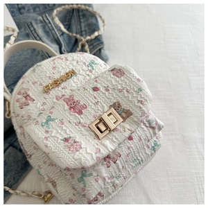 Detail des weißen gesteppten Rucksacks mit niedlichen Comic-Prints und goldenem Fashion-Logo
