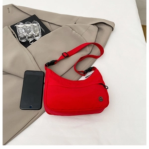Detail of red nylon crescent crossbody bag with adjustable strap and metallic M logo