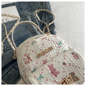 Detail des weißen gesteppten Rucksacks mit bunten Tierprints und goldenem FASHION-Logo