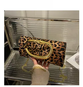 Detail of leopard print evening box bag featuring a bold oversized gold metal buckle