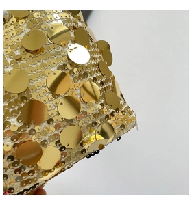 Détail macro de paillettes dorées brillantes sur un sac demi-lune avec chaîne