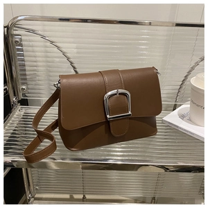 Detailed view of a brown vintage leather crossbody bag with a large silver buckle closure