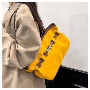 Détail du sac cabas en nylon jaune avec garniture en cuir brun et fermoir pivotant