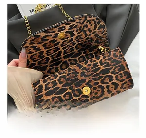 Detail of leopard print evening bag with golden round magnetic clasp and metal chain