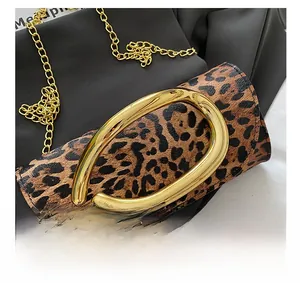 Detail of leopard print box bag featuring large gold oval buckle and fine chain strap