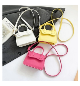Détail de mini sacs à main en cuir en blanc, jaune vif et rouge rose élégants