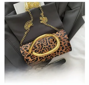 Detail showing leopard print clutch bag with bold gold buckle and chunky chain strap