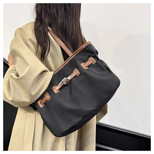 Mannequin portant un grand sac cabas en nylon noir avec finitions en cuir marron et fermoir