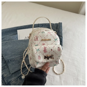 Detail of a mini quilted backpack with cute cartoon prints and a gold twist-lock closure