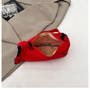 Red canvas crossbody bag detail showing zipper closure and spacious interior capacity