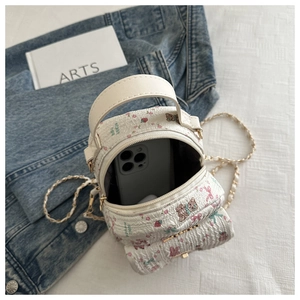 Close-up of small quilted backpack interior space with floral prints and pearl chain