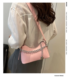 Detail of pink hobo bag with bold silver chain strap shown worn over the shoulder