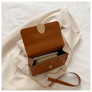 Top view of brown quilted bag interior showing capacity for smartphone and wallet