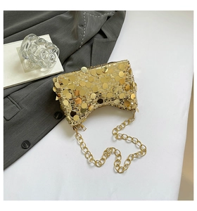 Détail d'un sac à paillettes dorées avec chaîne métallique et style de soirée chic