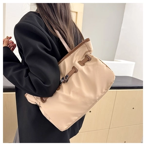 Détails des sangles contrastées et fermeture par cordon sur grand sac fourre-tout