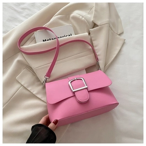 Close-up of Barbie pink leather shoulder bag with wide strap and silver metal buckle