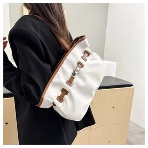 Détail d'un grand sac cabas contrasté avec fermoir rotatif argenté et lanières cuir