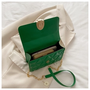 Detail view of green quilted crossbody bag interior with phone and wallet storage