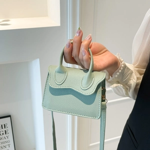 Mini sac à main vert menthe avec motif litchi, poignée et bandoulière en vue élégante