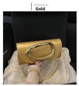Detailed view of luxury gold evening clutch with metal handle in premium gift box