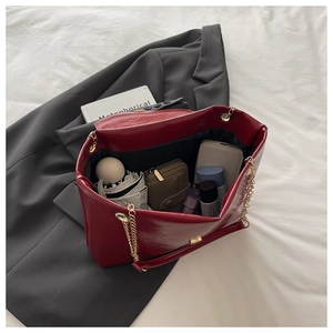 Top view of spacious burgundy leather tote interior with chain strap and daily essentials