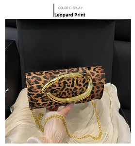 Detail of leopard print handbag with a large gold oval buckle and metallic chain strap