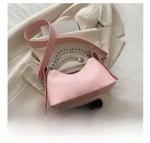 Detailed view of pink moon bag with silver chain handle and leather strap on a blazer