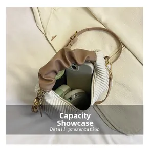 Capacity display of white pleated handbag showing smartphone and daily cosmetics inside