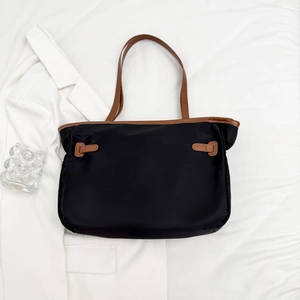 Sac fourre-tout minimaliste en nylon noir avec lanières marron sur tissu blanc