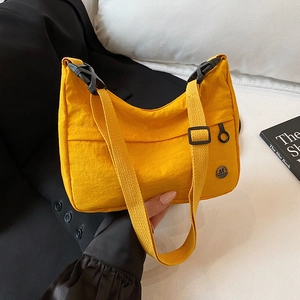 Minimalist yellow nylon crossbody bag with metal logo and adjustable strap for city style
