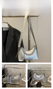 Detail view of silver metallic baguette bag featuring bold chain strap and sleek texture