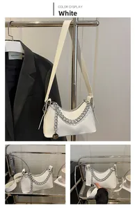 Detail of white PU leather underarm bag with silver chain and metal pendant