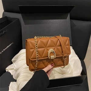 Brown quilted crossbody bag with gold hardware in an elegant gift box set