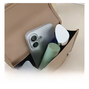 Internal capacity view of beige PU leather crossbody bag showing space for phone and makeup