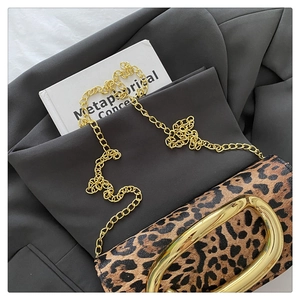 Detailed view of leopard print faux leather texture with a gold metal oval buckle