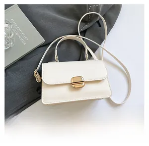 Detail view of the elegant ivory white leather handbag with golden rectangular metal buckle