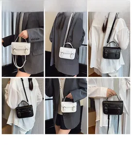 Detail view of retro PU leather crossbody bag with double buckle straps in black and white