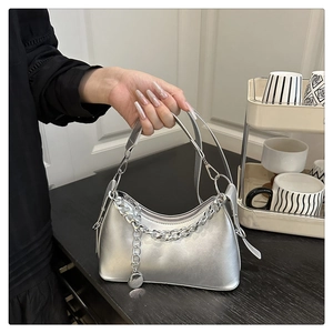 Silver crescent shoulder bag with metallic finish, thick metal chain and round pendant