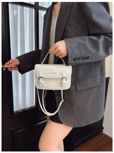 Detail of white mini square bag with silver buckles and Fashion & Bag lettering