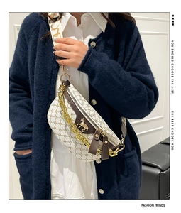 Detail of cream crossbody bag with vintage pattern, gold horse logo, and thick chain strap