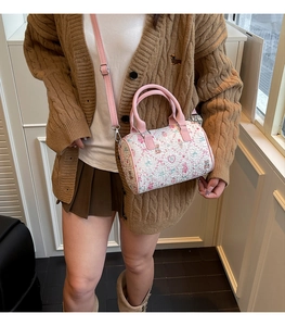 Detail of cute bear pattern on cylindrical pink white crossbody bag with silver hardware