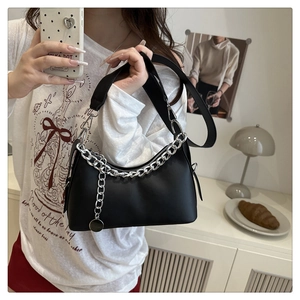 Detail of black crescent shoulder bag with silver chain accessory and adjustable strap