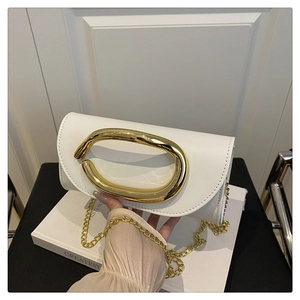 Detail of white leather flap bag with oval gold handle and elegant metal chain strap