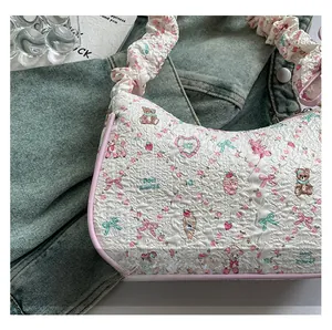 Detail of floral bear pattern on pleated white shoulder bag with pink leather trim