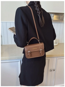 Brown vintage PU leather crossbody bag with dual buckles and adjustable strap on a model