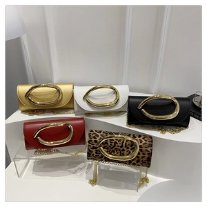 Detail of elegant clutch bags with stylish metal handles and detachable chain straps