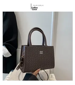 Detail of coffee brown woven faux leather tote bag with silver logo and top handles