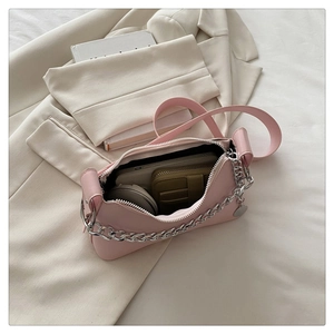 Internal view of pink chain shoulder bag holding a phone, wallet, and makeup powder