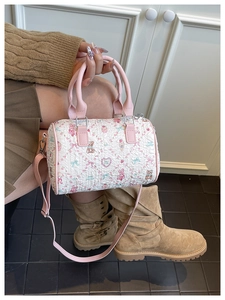 Detailed view of white embossed cylinder bag with pink bear and bow cartoon prints